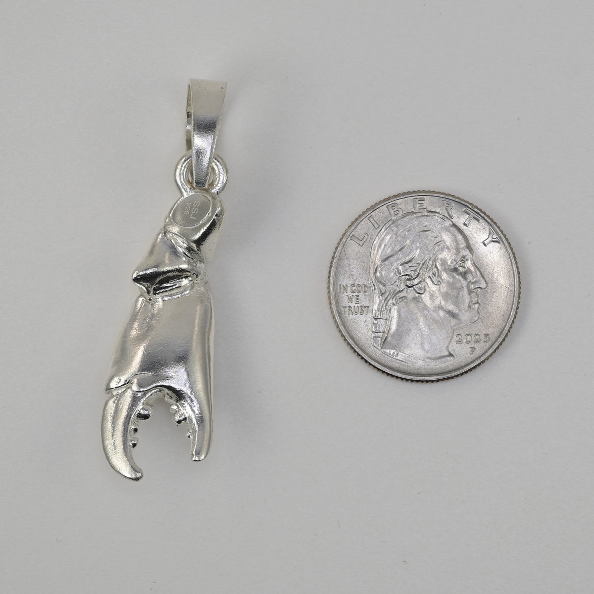 Stonecrab claw made in sterling silver size referenced next to a quarter