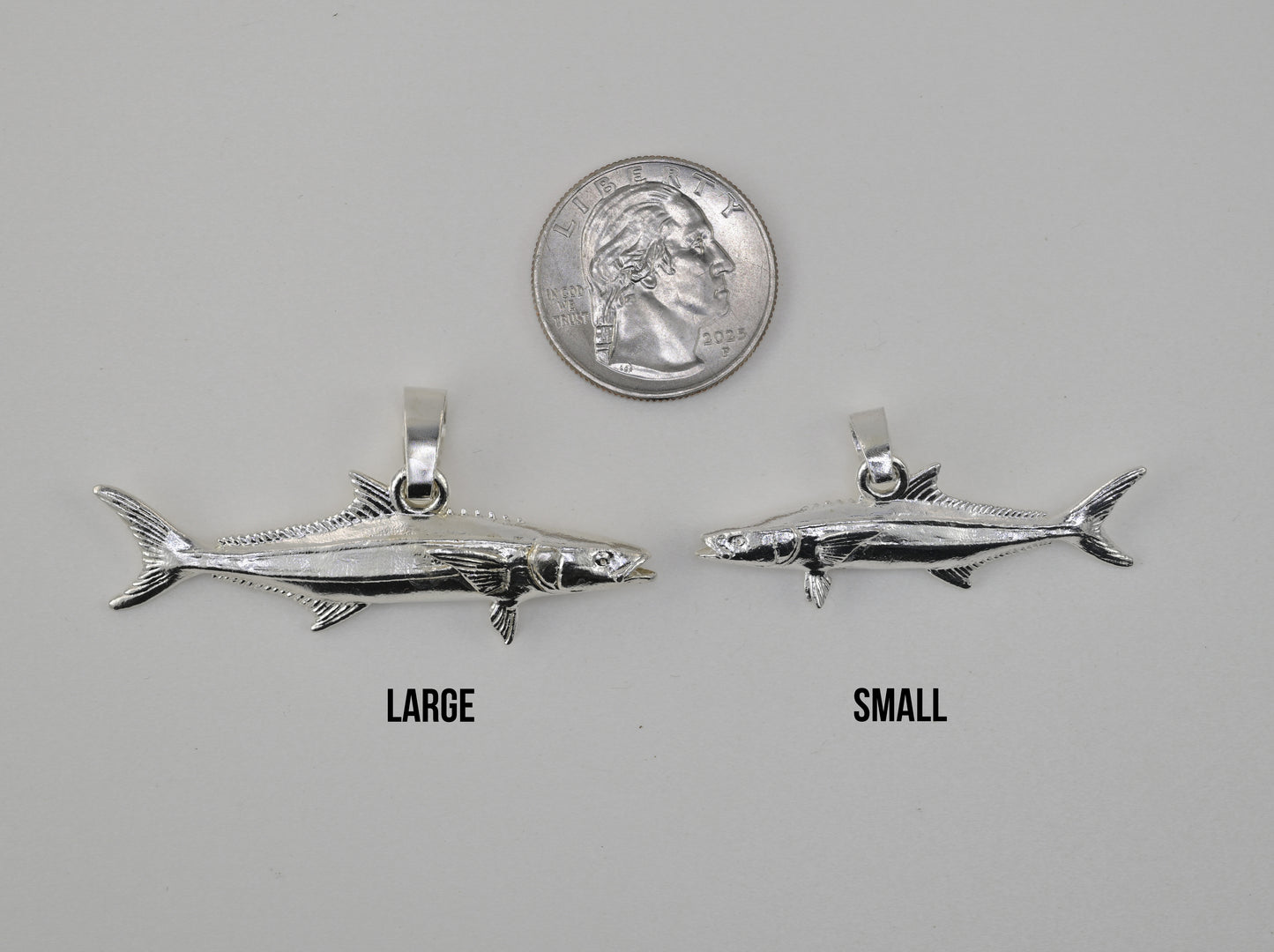 Cobia pendant small vs large size comparison next to a quarter 