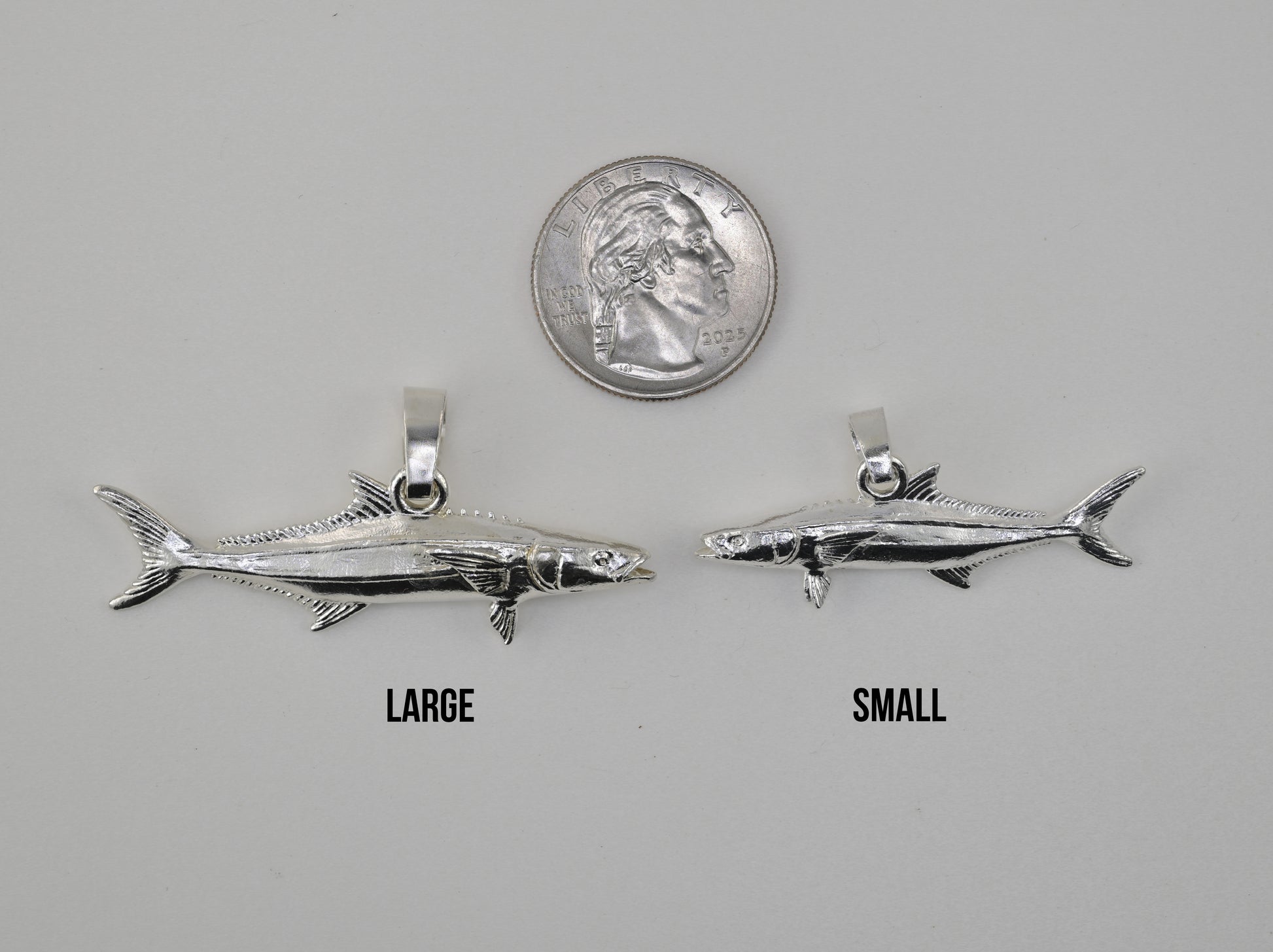 Cobia pendant small vs large size comparison next to a quarter 