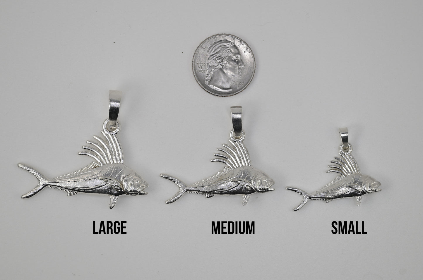 The Large Medium and Small Roosterfish next to each other and next to a quarter for size reference