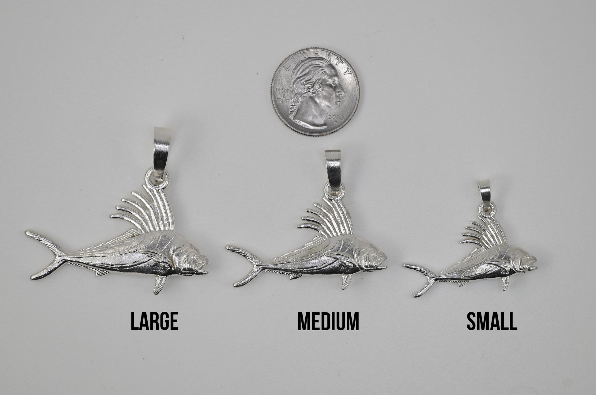 The Large Medium and Small Roosterfish next to each other and next to a quarter for size reference