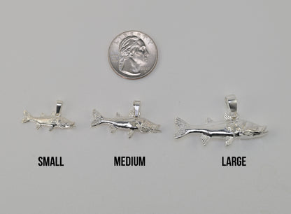 Three silvers snook fish shaped pendant charms labeled SMALL, MEDIUM, and LARGE are shown on a light gray background with a U.S. quarter
