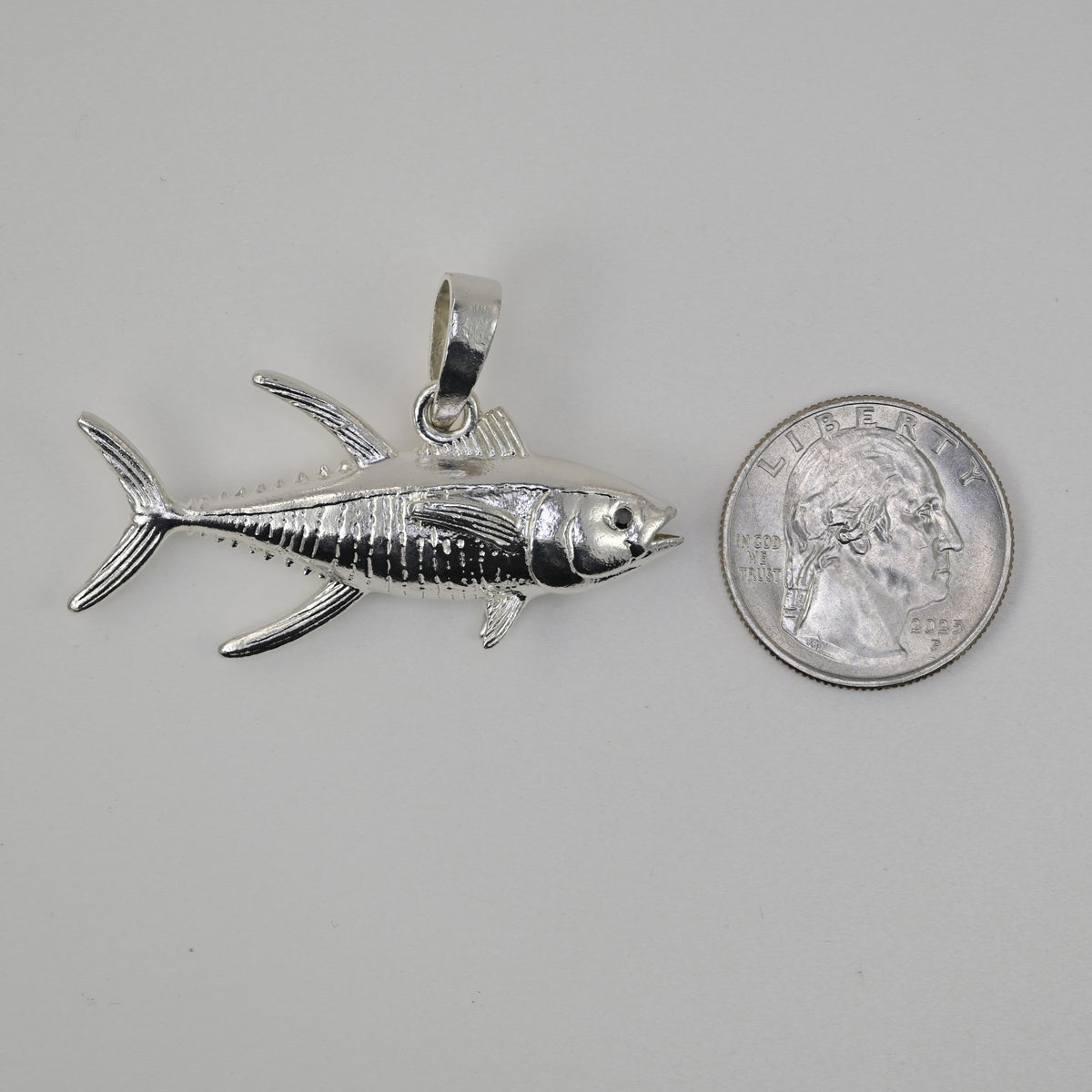 Yellowfin tuna made in solid sterling silver size referenced next to a quarter